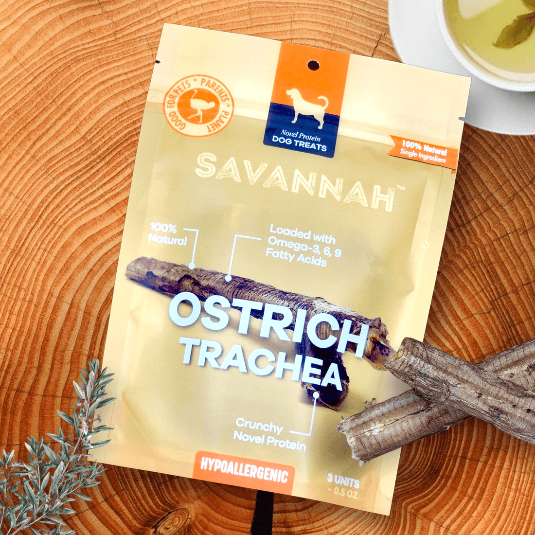 Dog treat packaging on a wooden surface, labeled 'Ostrich Trachea' and 'Hypoallergenic.'